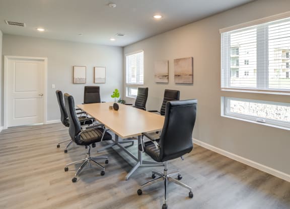 a conference room with a table and chairs and a window