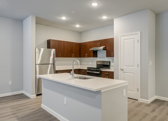 a kitchen with an island and a stainless steel refrigerator