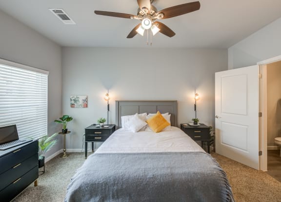 a bedroom with a large bed and a ceiling fan