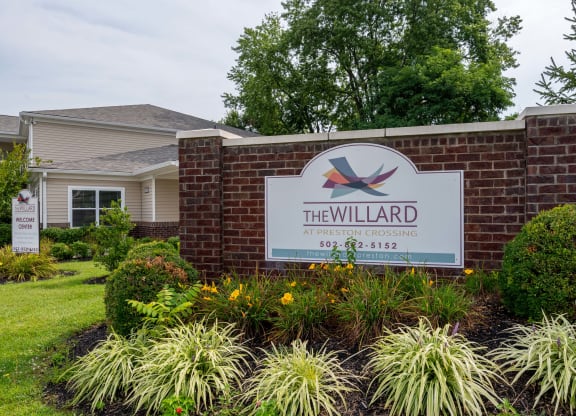 the willard neighborhood entrance sign in front of a brick wall