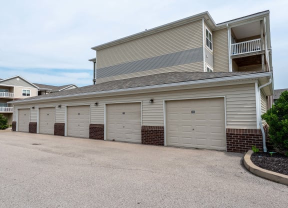 a garage with a row of white doors on the side of a house