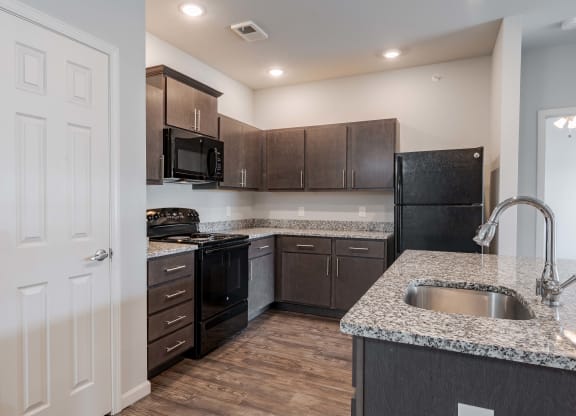 a kitchen with granite counter tops and black appliances