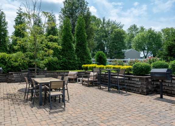 a patio with tables and chairs on a brick patio