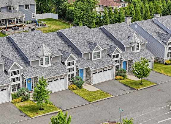 A row of houses with grey roofs and white windows.
