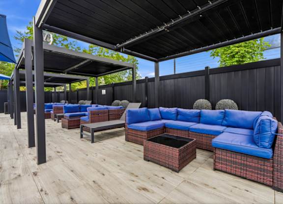 Covered outdoor lounge with blue sectional seating at The Franklin at Marlboro Apartments, Marlboro, 07746