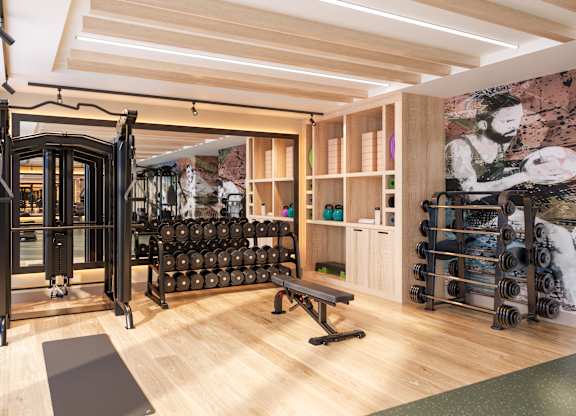 A gym with a variety of equipment including weights and a bench.