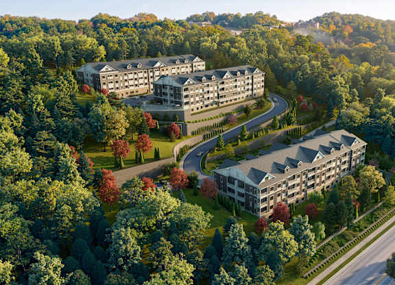 A large building complex is surrounded by trees in the image.