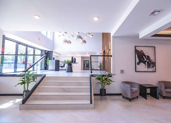 A spacious lobby with a staircase, chairs, and a large painting on the wall.at The Franklin at Westfield, New Jersey, 07090