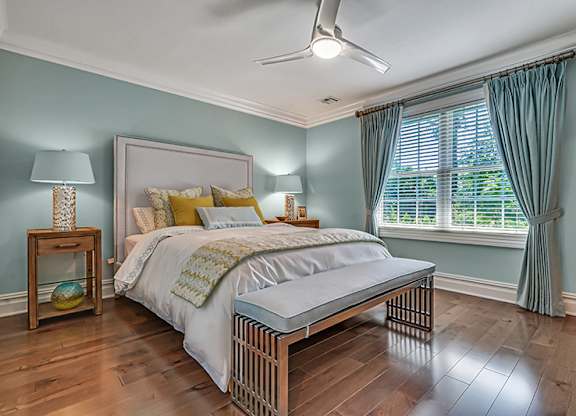 A bedroom with a bed, nightstand, and window.