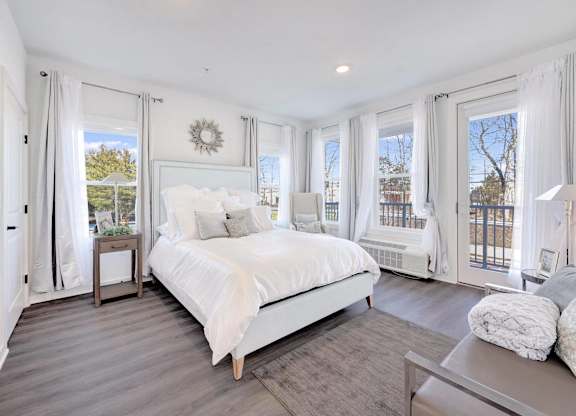 a white bedroom with a large bed and windows at The Franklin at Hillsborough Apartments, Hillsborough, New Jersey