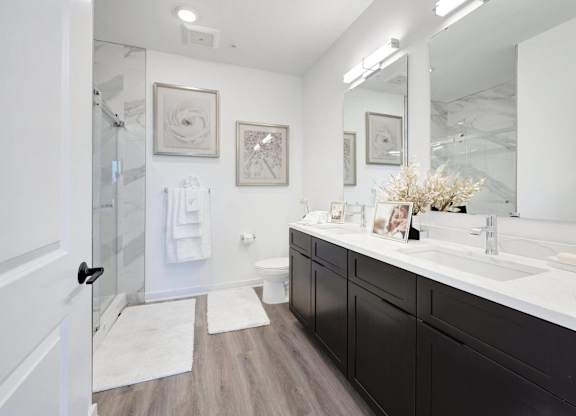 a white and black bathroom with a shower and sink at The Franklin at Hillsborough Apartments, NJ,08844
