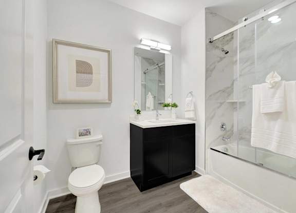 a bathroom with a shower toilet and a sink at The Franklin at Hillsborough Apartments, Hillsborough, NJ