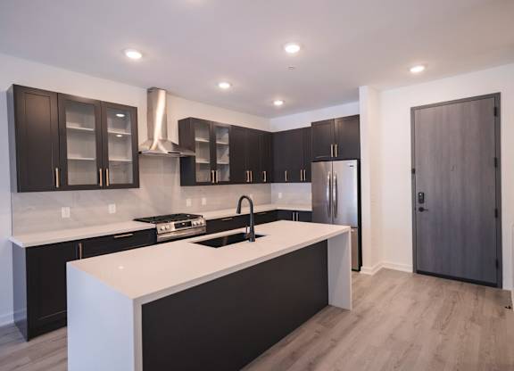 a kitchen with a white counter top and black cabinets at The Franklin at Westfield, New Jersey, 07090