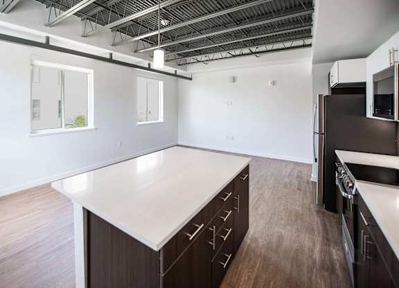 A kitchen with a white countertop and dark wood cabinets at Elements on Third Apartments, St. Petersburg, FL