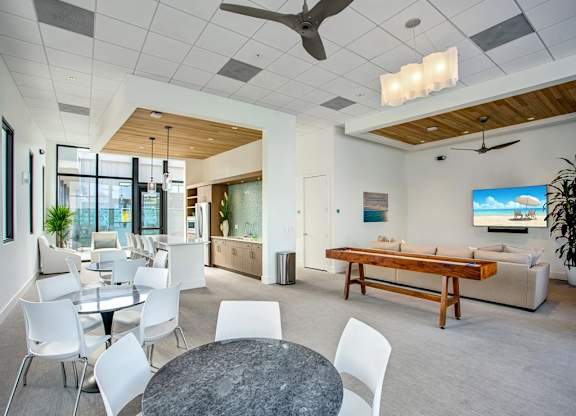 a game room with a pool table and chairs at Elements on Third Apartments, St. Petersburg