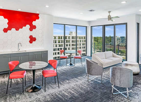 a room filled with furniture and a table with chairs at Elements on Third Apartments, St. Petersburg, FL