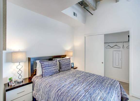 a bedroom with a bed and a closet at Elements on Third Apartments, St. Petersburg
