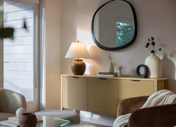 a living room with a lamp and a mirror