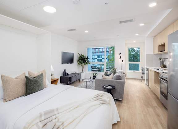 a bedroom with a bed and a living room with a tv