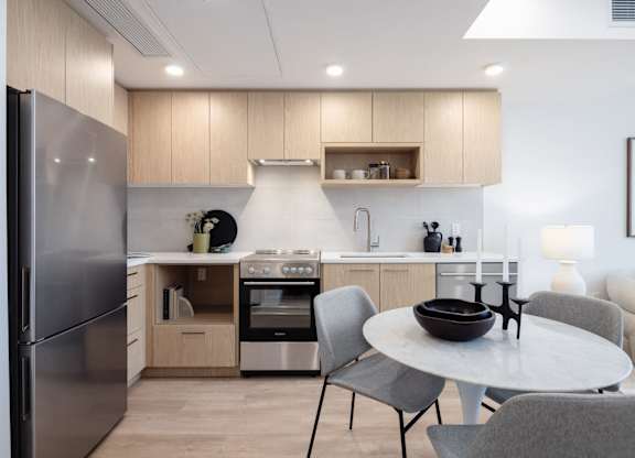 a kitchen with stainless steel appliances and a table with chairs