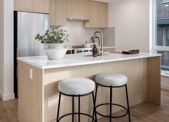 a kitchen with a counter and two stools