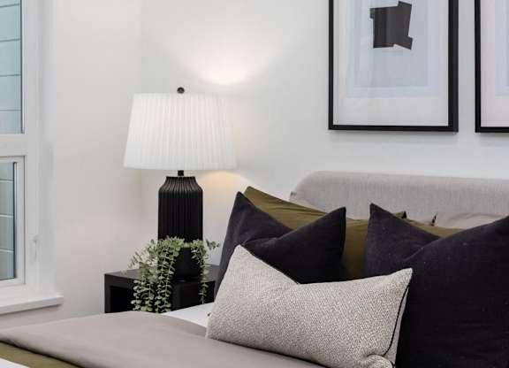 a bedroom with a bed and a lamp and pictures on the wall