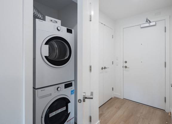 a washer and dryer in a white room with a white door