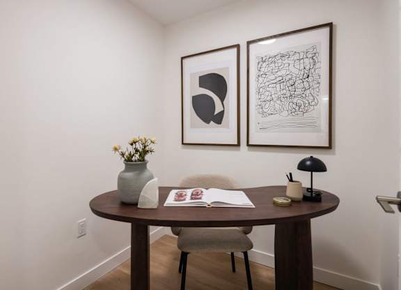 a small table in a room with two pictures on the wall