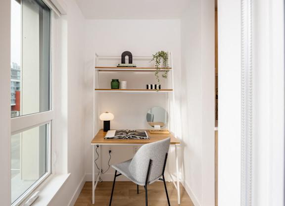 a home office with a desk and a chair in front of a window
