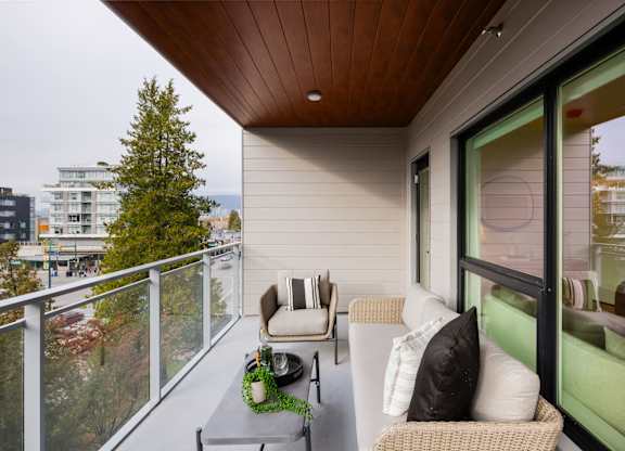 a balcony with a couch and chairs and a table