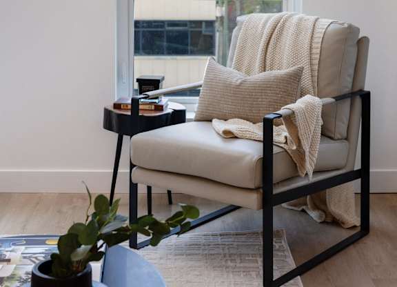 a chair with a pillow and a table in front of a window