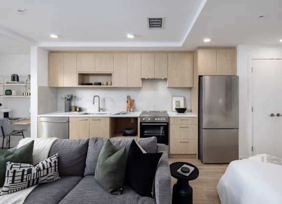 a living room with a couch and a kitchen