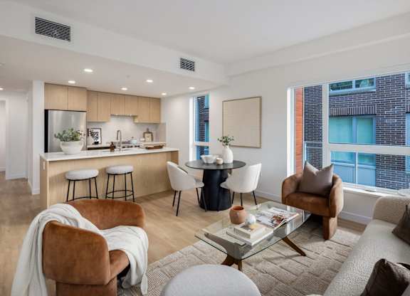 a living room with a kitchen and a large window