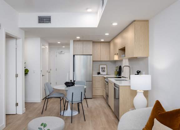 a kitchen and dining area with a table and chairs and a refrigerator