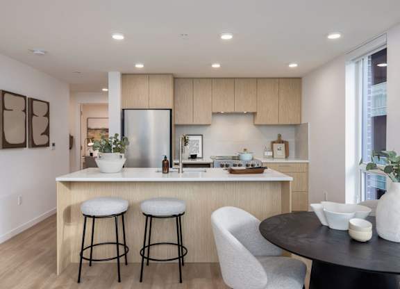 a kitchen with a bar and two stools in front of a