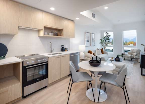 a kitchen and living room with a table and chairs