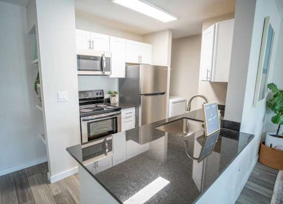 A modern kitchen with a stainless steel refrigerator and microwave.