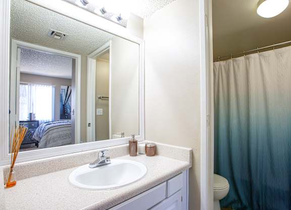 A bathroom with a white sink and a blue shower curtain.