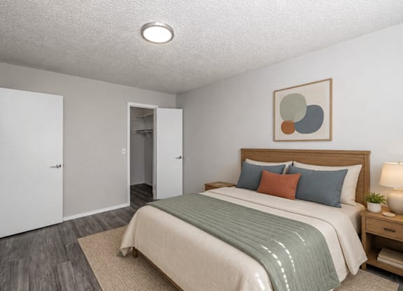 A bedroom with a bed, nightstand, and two doors.