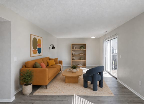 A living room with a sofa, armchair, and a rug.