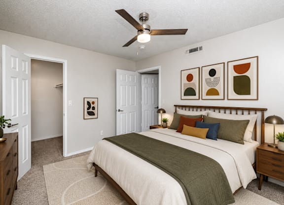 A bedroom with a bed, dresser, and ceiling fan.