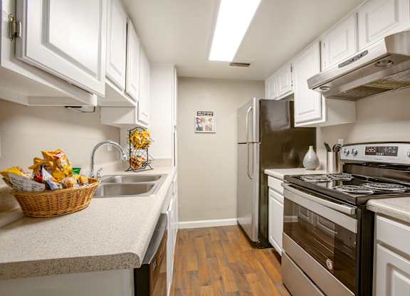 A kitchen with white cabinets and a stainless steel refrigerator.
