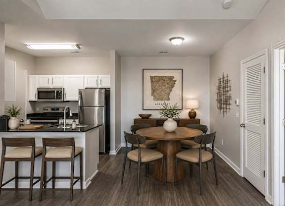 A kitchen with a table and chairs in the middle of the room.