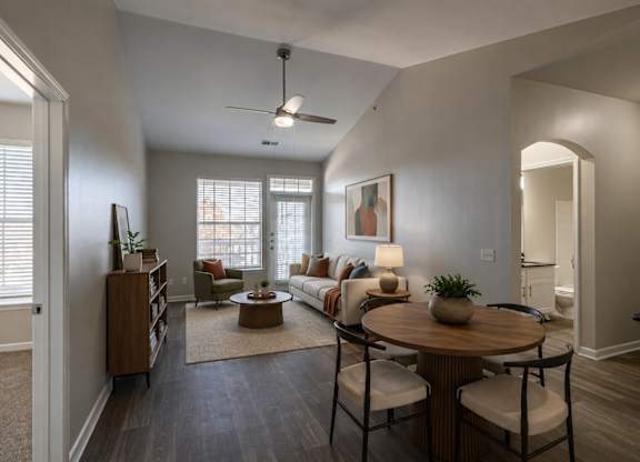 A living room with a couch, a coffee table, and a ceiling fan.