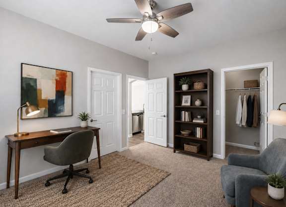 A room with a desk, chair, and a ceiling fan.