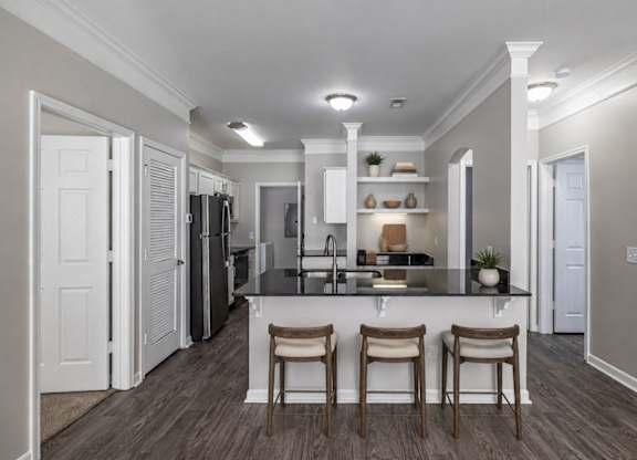 A kitchen with a bar stool and a counter.
