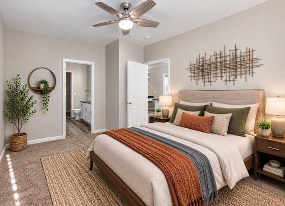 A bedroom with a large bed and a ceiling fan.