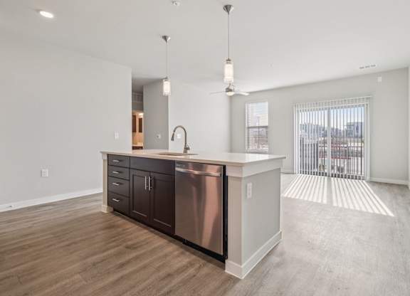 A modern kitchen with a stainless steel sink and wooden floors.