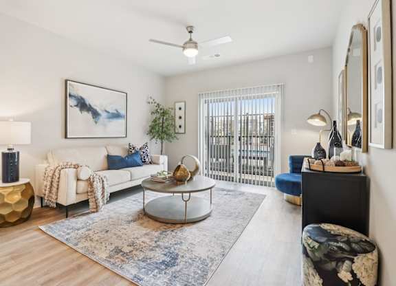 A living room with a white couch, a coffee table, and a painting on the wall.