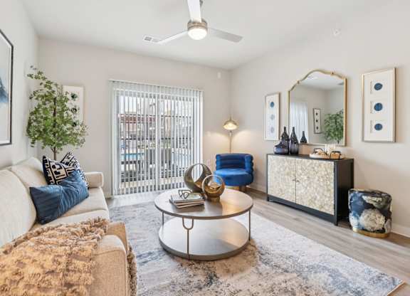 A living room with a beige couch, a round coffee table, and a blue chair.